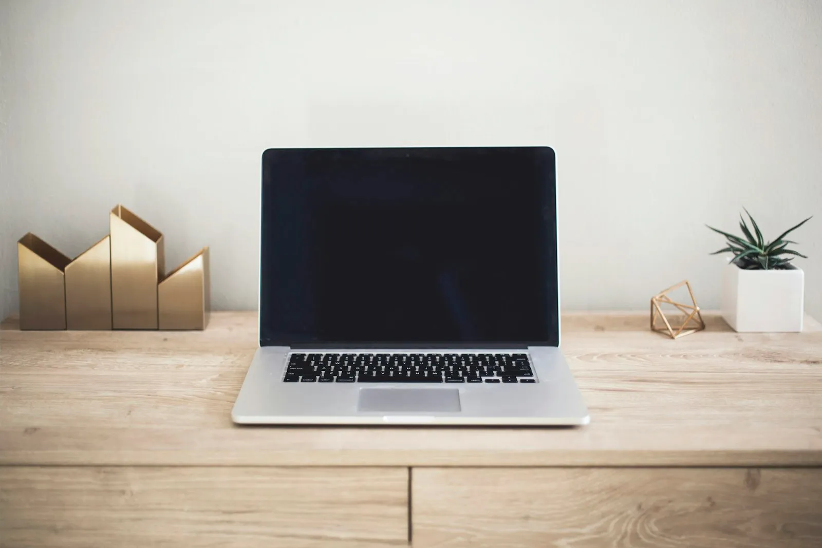 An open laptop on a light wooden desk